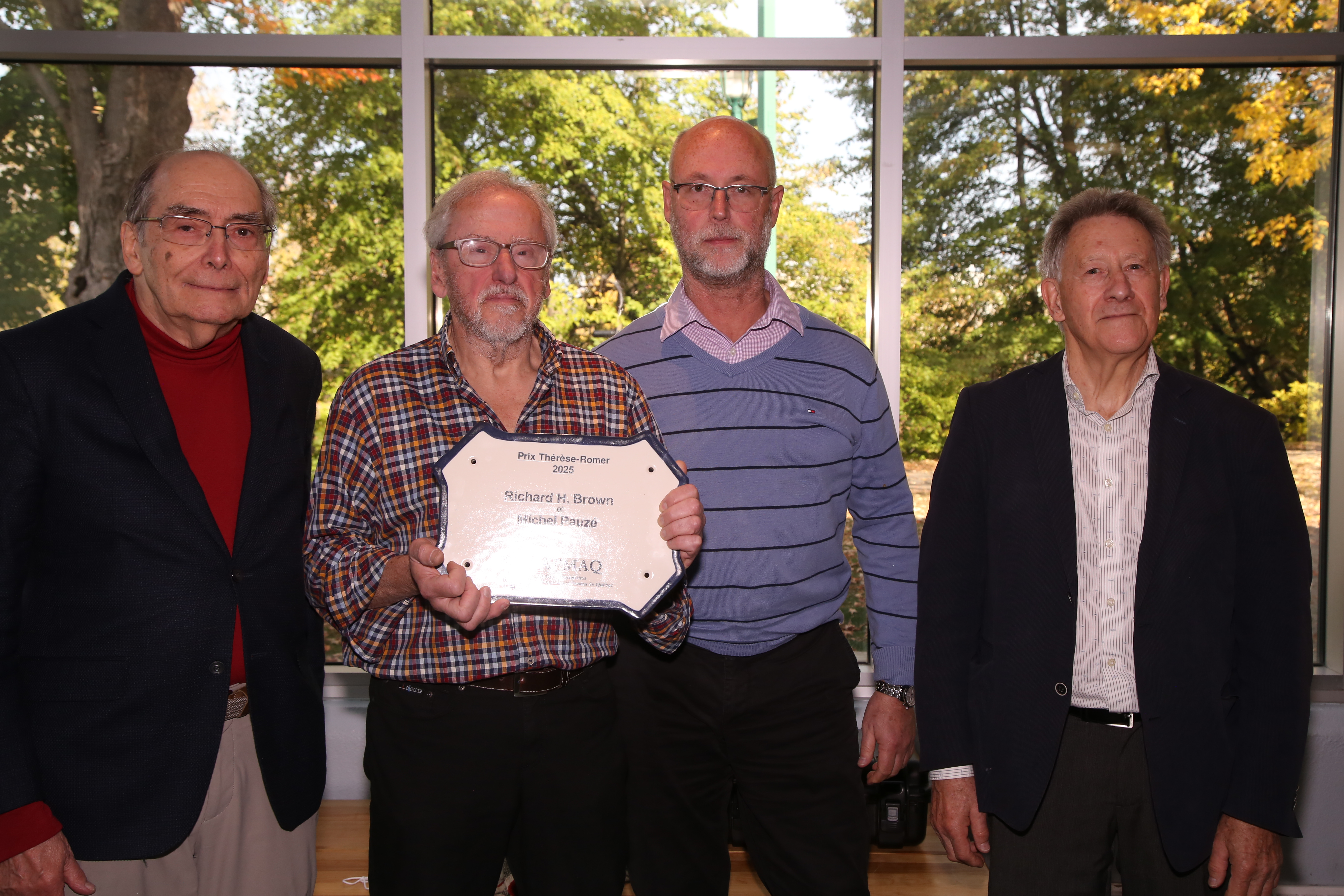 Louis Patenaude, précédent président et responsable du comité des prix, accompagné de Michel Pauzé et Richard H.Brown, récipiendaires du prix Thérèse-Romer 2025 et de Clément Locat, président de l’association.  Crédits photos: Jean Chevrette