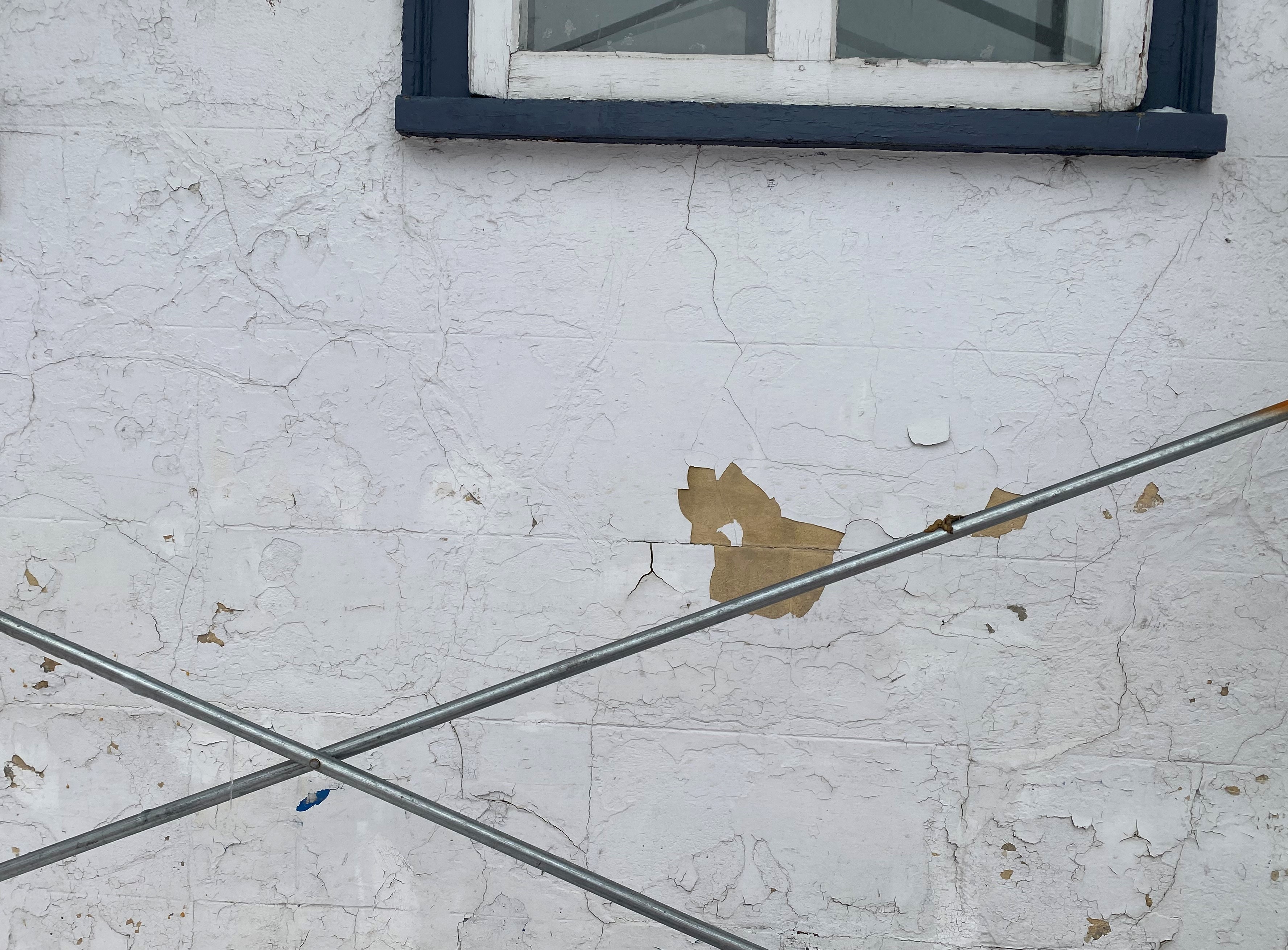 Soulèvement de la couche de finition (peinture) dû à une incompatibilité avec l’enduit.