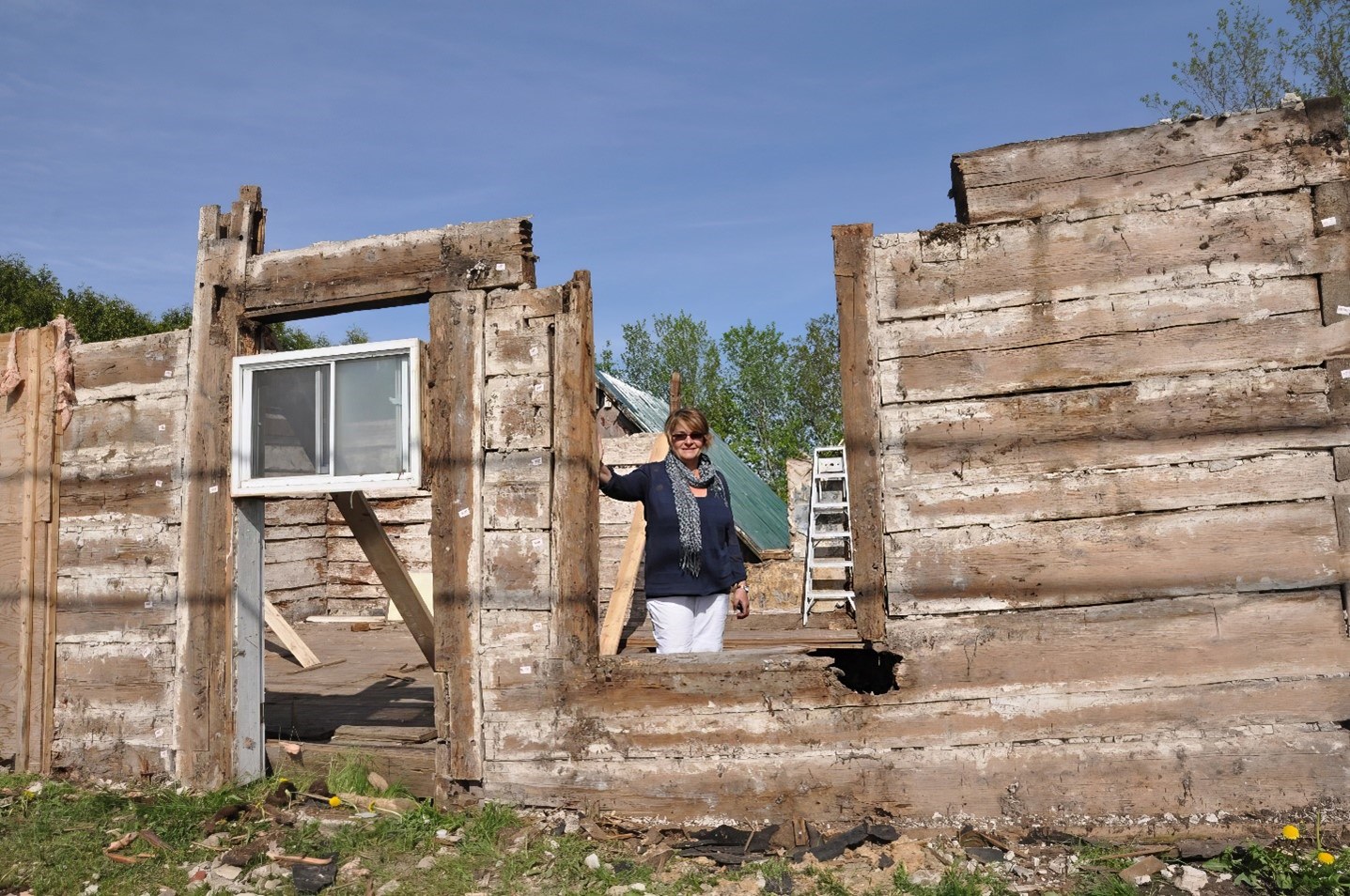 Photo 2 – Pendant le démontage de la maison, toit déplacé, Marjolaine Mailhot au centre, printemps 2012.