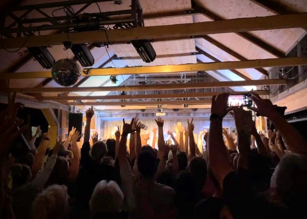 I 17 Le côté est et l’arrière de la grange en mai 2022. Des spectateurs enthousiastes à l’intérieur de la grange devenue salle de spectacle.
