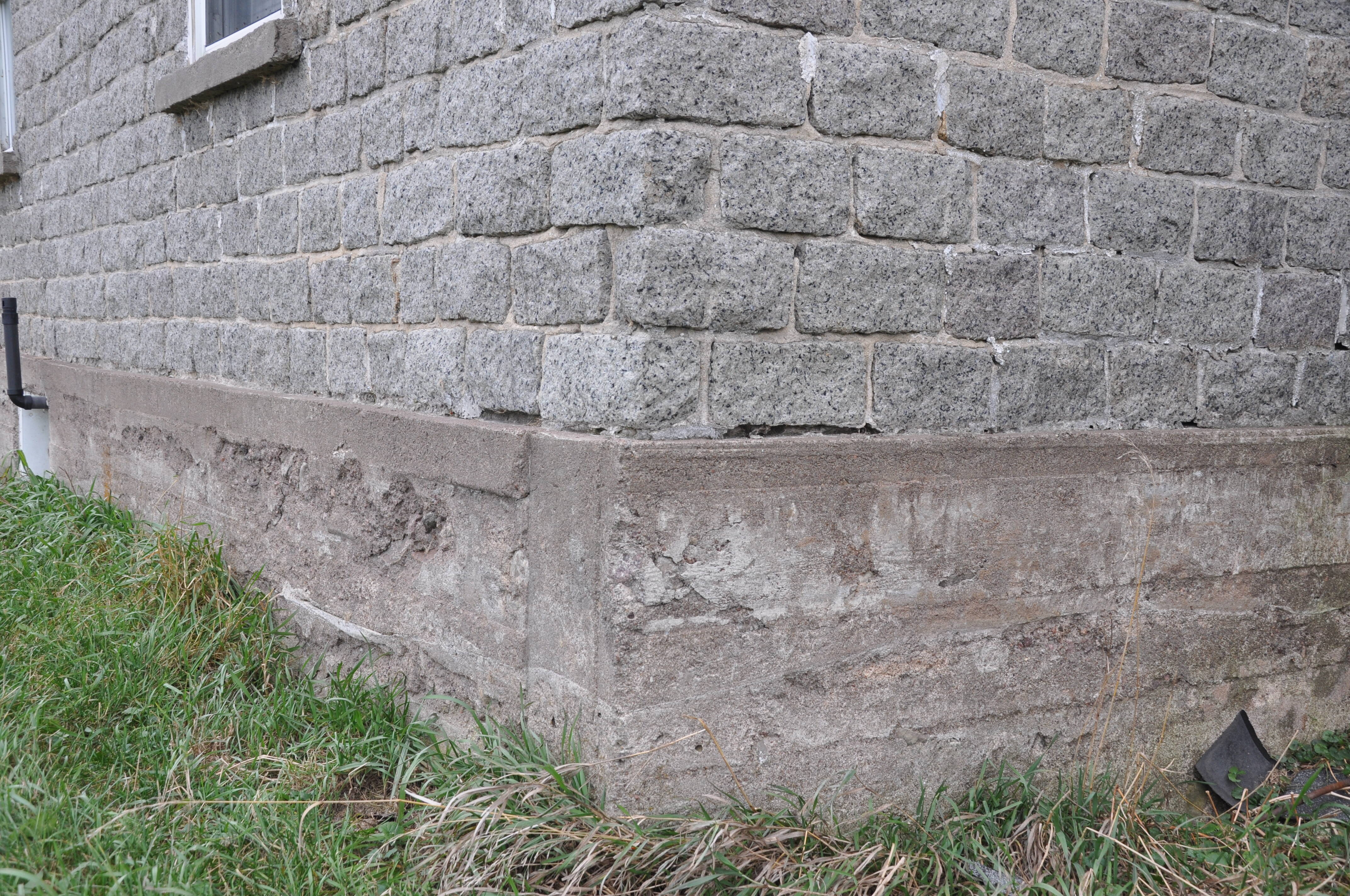 Fondation en béton, premier quart du XXe, dont le mur sud présente de l’écaillage. Noter la largeur des planches des coffrages, Brownsburg, Laurentides.