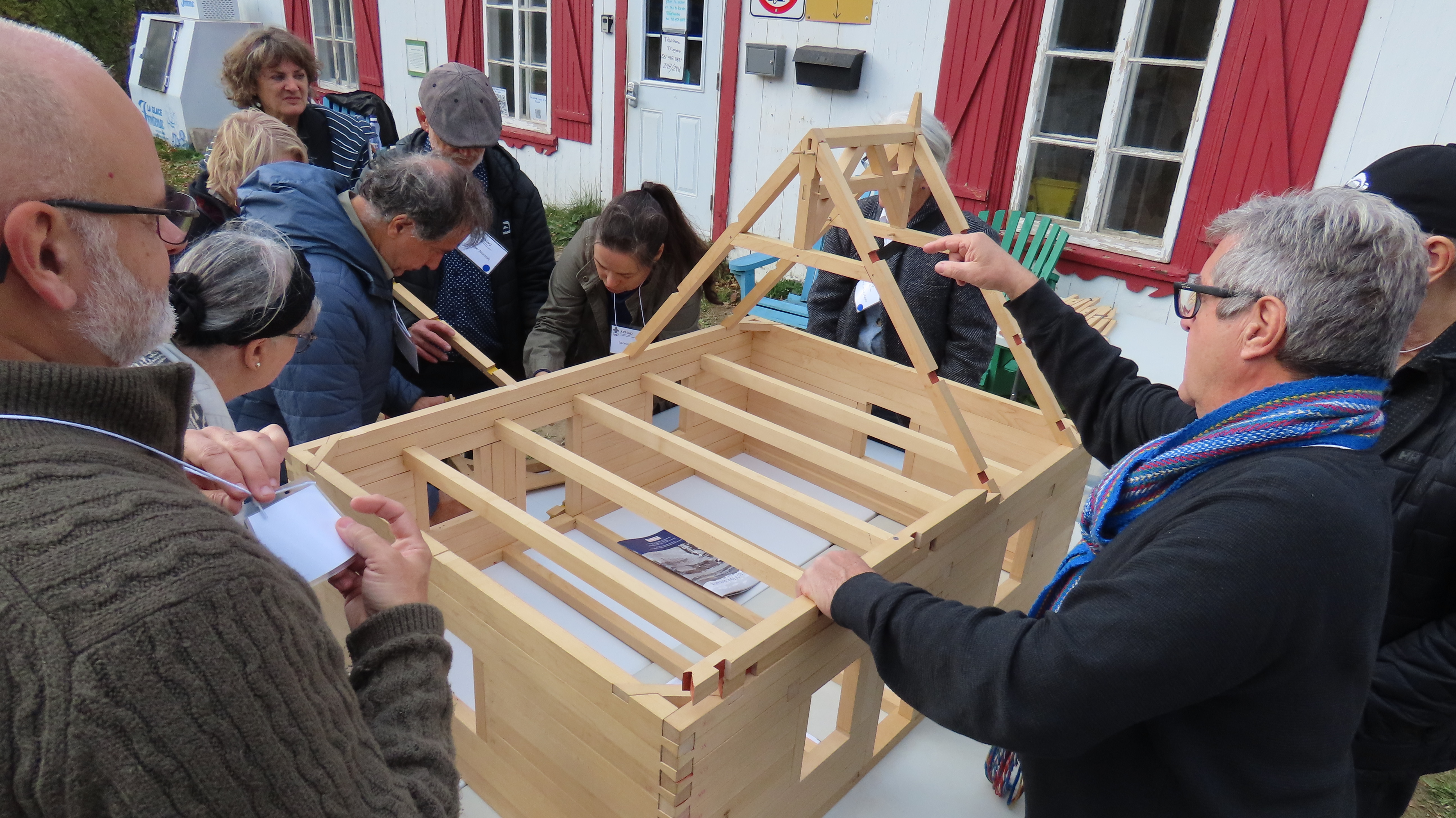 Avec Isabelle Paradis, les participants au Congrès assemblent la structure en pièce-sur-pièce d’une maquette de maison de l’Ile.