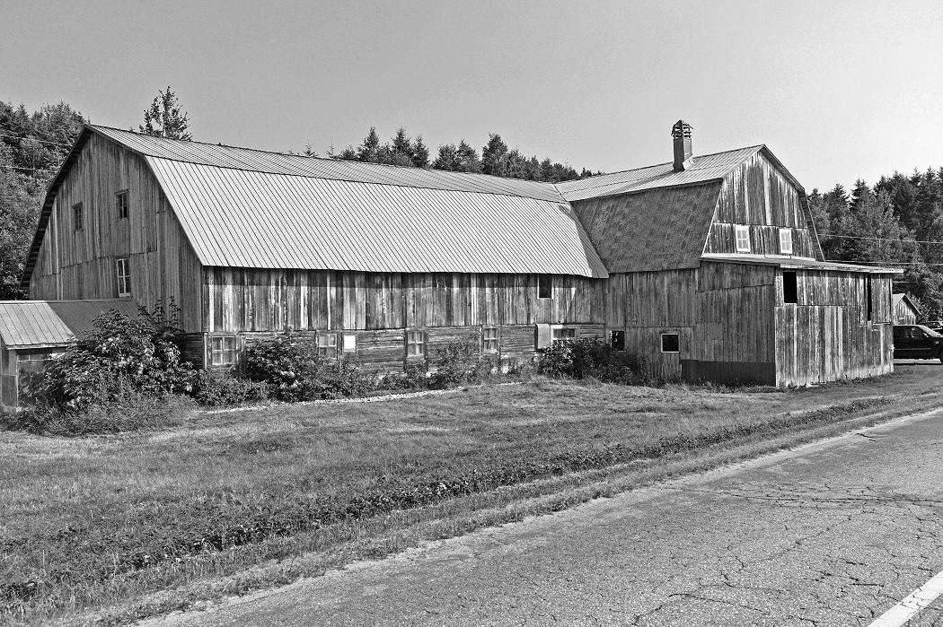 Grange de style à comble brisé de Charlevoix, regroupement dans un seul édifice des bâtiments-blocs (milieu du 20e).